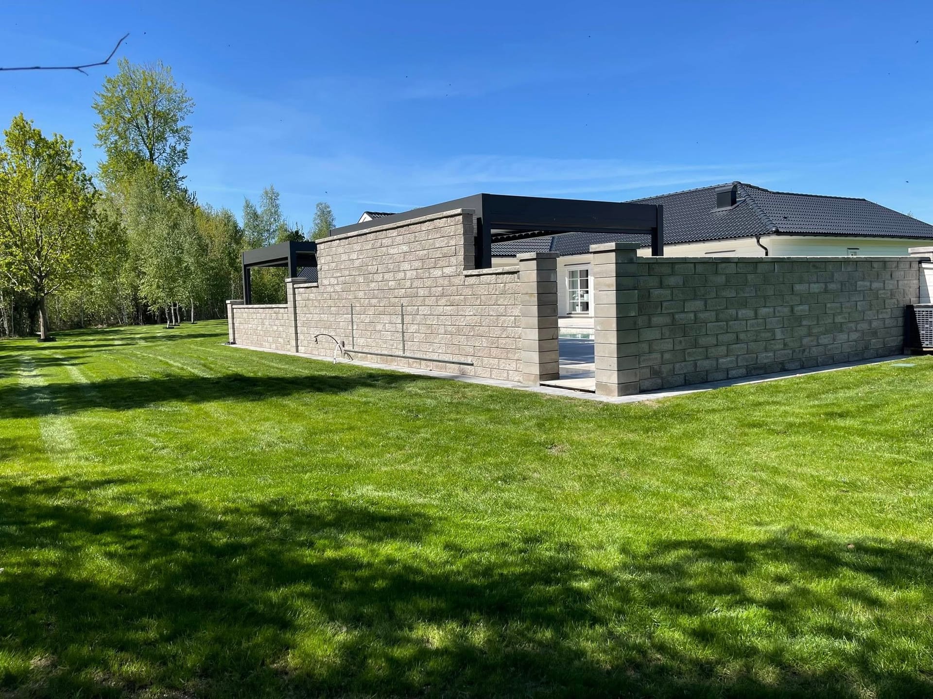Stenmur och välskött gräsmatta med ränder